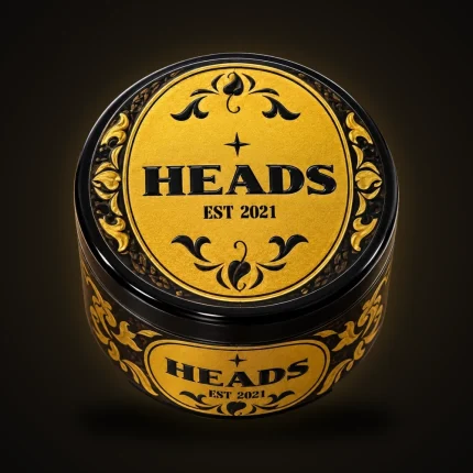 A black and gold HEADS Est. 2021 jar with an ornate lid