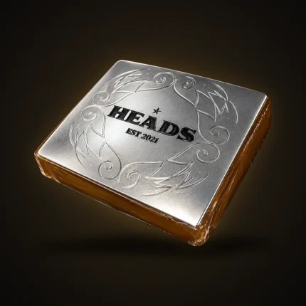 A slab of static sift under an engraved silver HEADS Est. 2021 lid